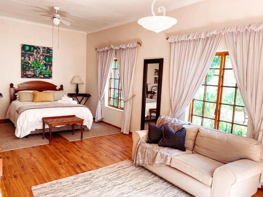 Un dormitorio con cama, mesita de noche, lámpara y vistas al exterior.