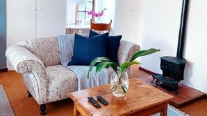 Una sala de estar con un sofá, una mesa de centro, una lámpara y una chimenea.