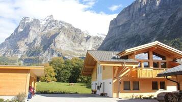 Un chalet en bois doté d’un balcon, d’un garage et offrant une vue sur la montagne.