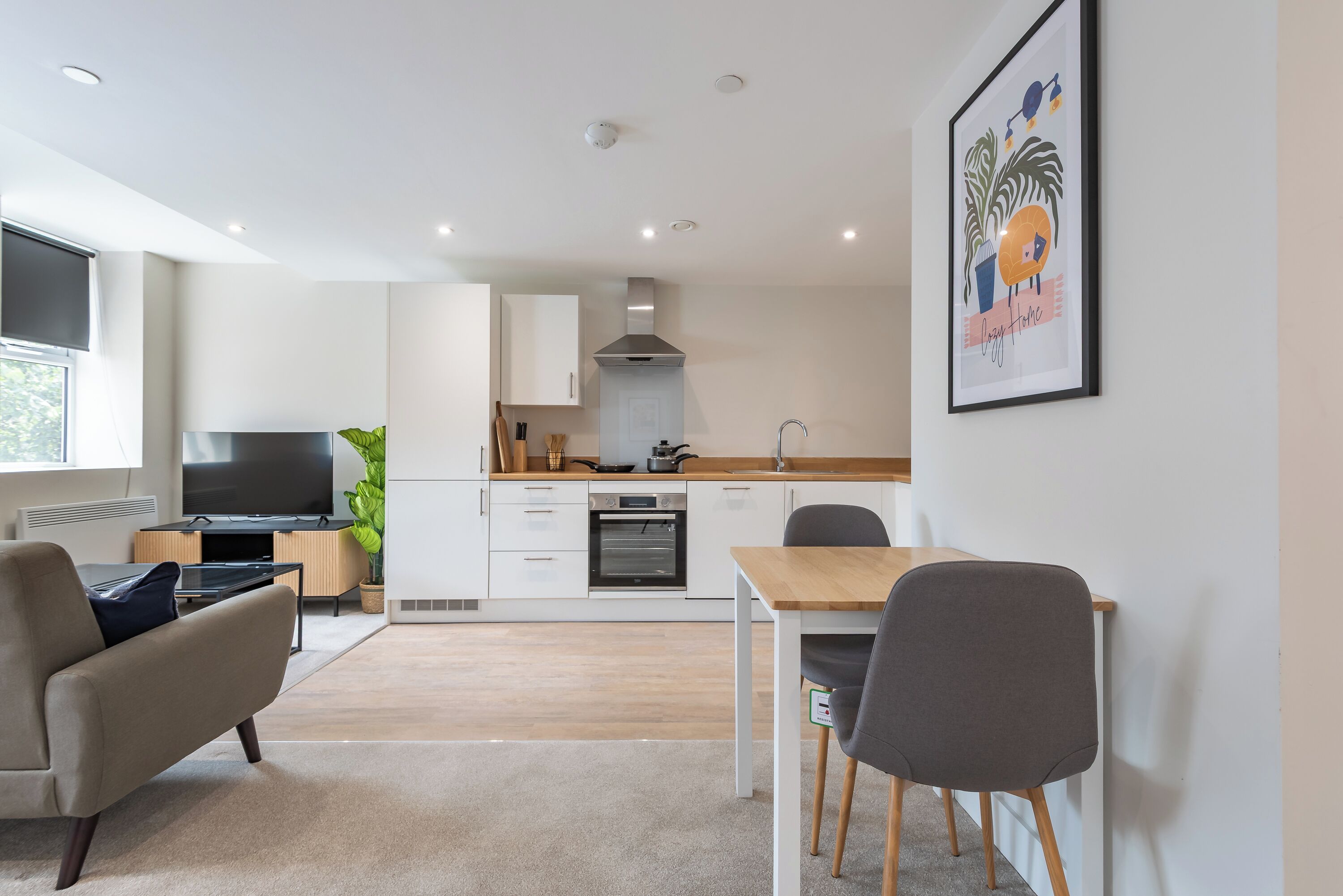 A modern living room with a TV, sofa, and dining area with chairs.