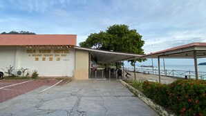 A hotel entrance with a sign reading 'SEA VIEW HOTEL & HOLIDAY RESORT SDN BHD.'