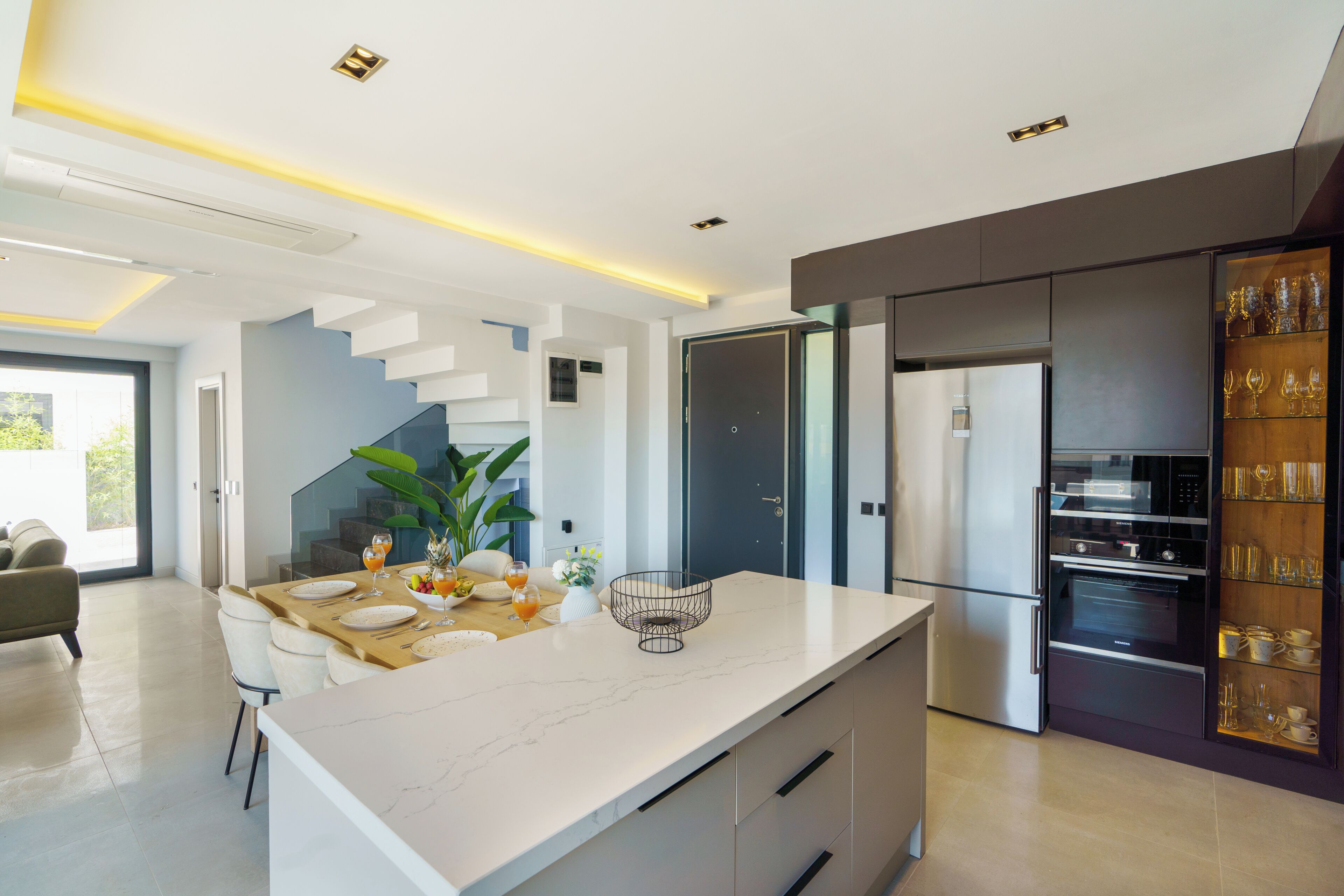A modern kitchen with a marble countertop, built-in oven, and a wine rack.