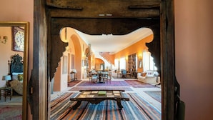 Een interieur met een centrale tafel, een trap en een zithoek.