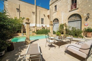 A courtyard with a pool, outdoor furniture, and stone buildings. - Historic gem with antiques & private pool (Santa Cesarea Terme)