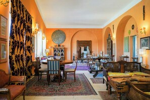 A spacious room with a dining area, a large round mirror, and a view of the street. - Historic gem with antiques & private pool (Santa Cesarea Terme)