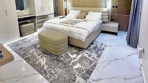 Un dormitorio moderno con una cama grande, una mesita de noche, un armario y un espejo.