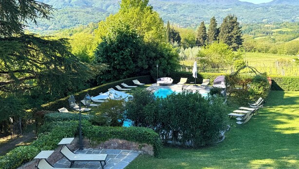 Un espace piscine avec des chaises longues, un jacuzzi et une vue sur les montagnes.