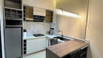 Een moderne keuken met inbouwapparatuur, een centraal eiland en hanglampen.