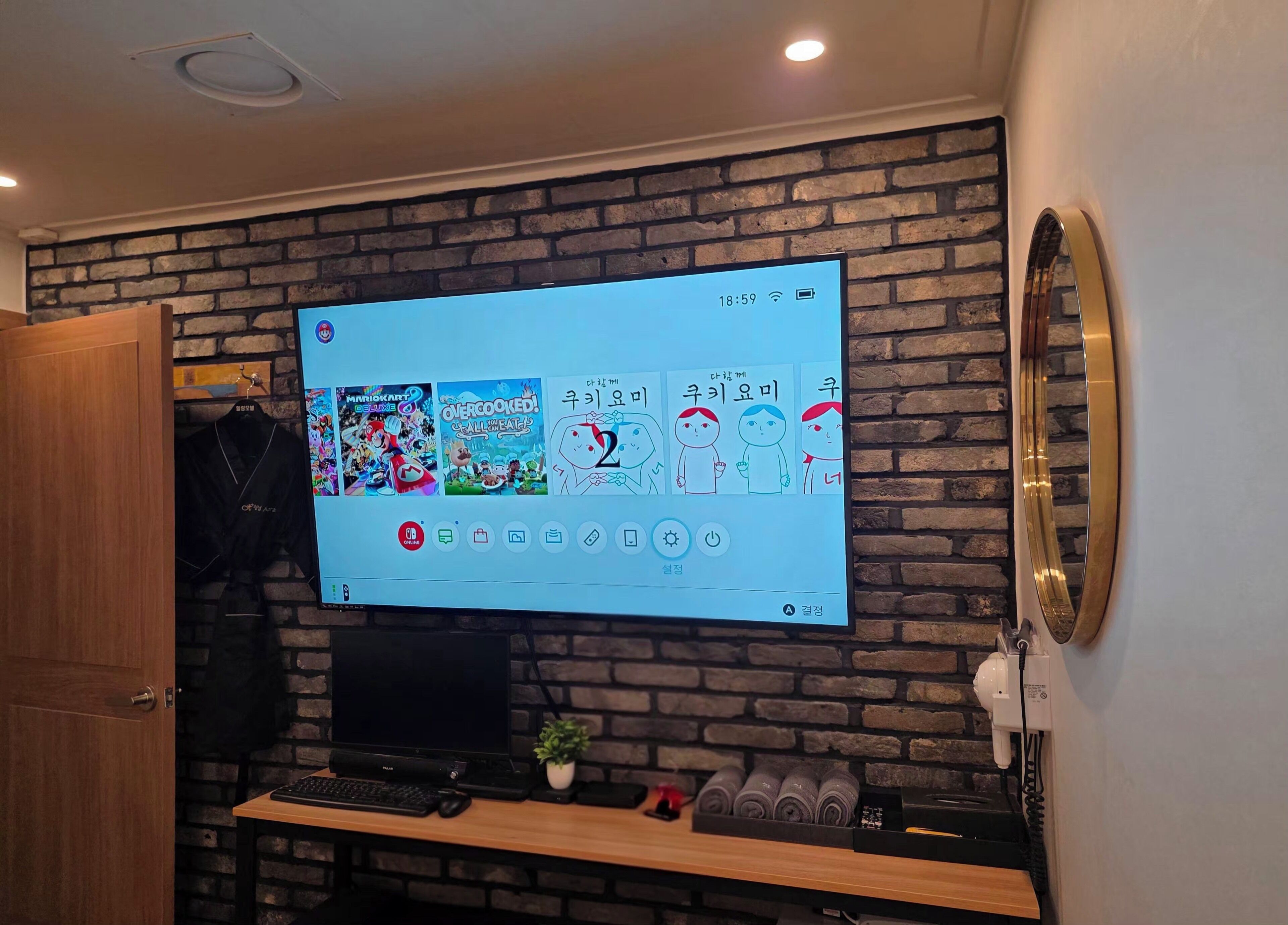 A flat-screen TV mounted on a brick wall displaying a video game interface.