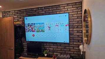 A flat-screen TV mounted on a brick wall displaying a video game interface.