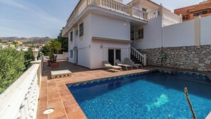 A two-story house with a swimming pool, outdoor furniture, and a view of the landscape. - 143 - Spacious Villa with Private Pool & Stunning Views (Fuengirola)