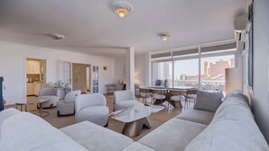 A modern living room with a sofa, armchairs, a coffee table, and a dining area with chairs and a table. - 143 - Spacious Villa with Private Pool & Stunning Views (Fuengirola)