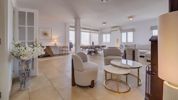 A spacious living area with a sofa, armchairs, and a coffee table. There is a dining table with chairs in the background. - 143 - Spacious Villa with Private Pool & Stunning Views (Fuengirola)