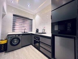 Apartamento Deluxe, balcón, vistas a la ciudad | Cocina privada | Frigorífico, microondas, horno y placa de cocina