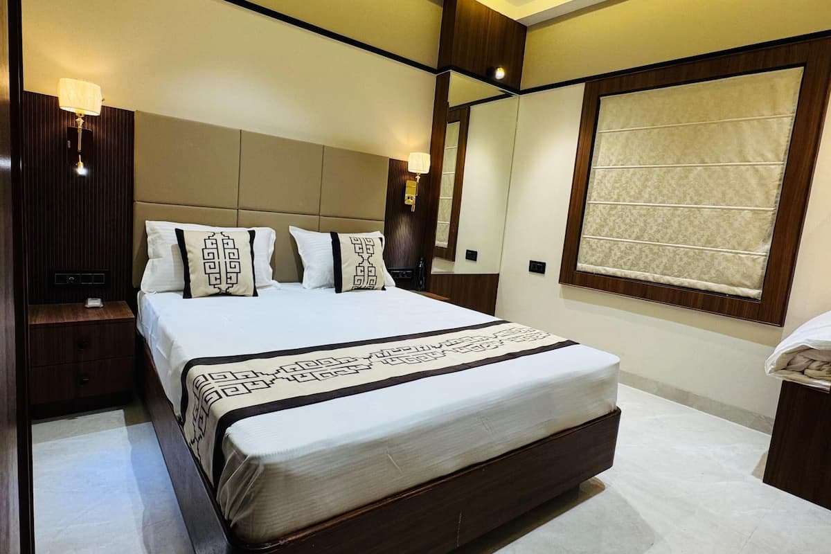 A modern bedroom with a large bed, a ceiling fan, recessed lighting, and a large window with a view.