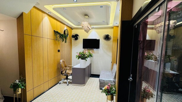 Zona de recepción con diseño moderno, que incluye mostrador de recepción, área de descanso y plantas decorativas.