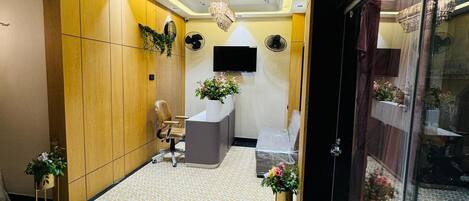 A reception area with a modern design, including a reception desk, seating area, and decorative plants.