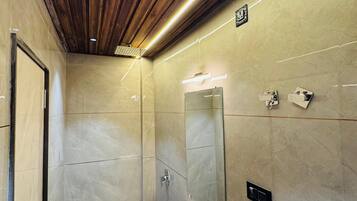 Un baño moderno con techo de madera, un espejo grande, un lavabo y una ducha.