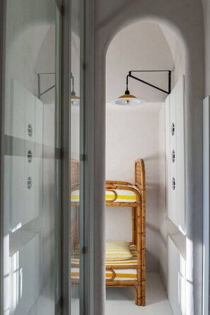 A narrow hallway with a bunk bed, a glass door, and a pendant light. - Villa Eletta, Capri (Marina Grande)