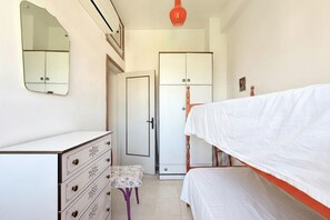 Ein Schlafzimmer mit einem Bett, einem Schminktisch, einem Kleiderschrank und einem kleinen Tisch.