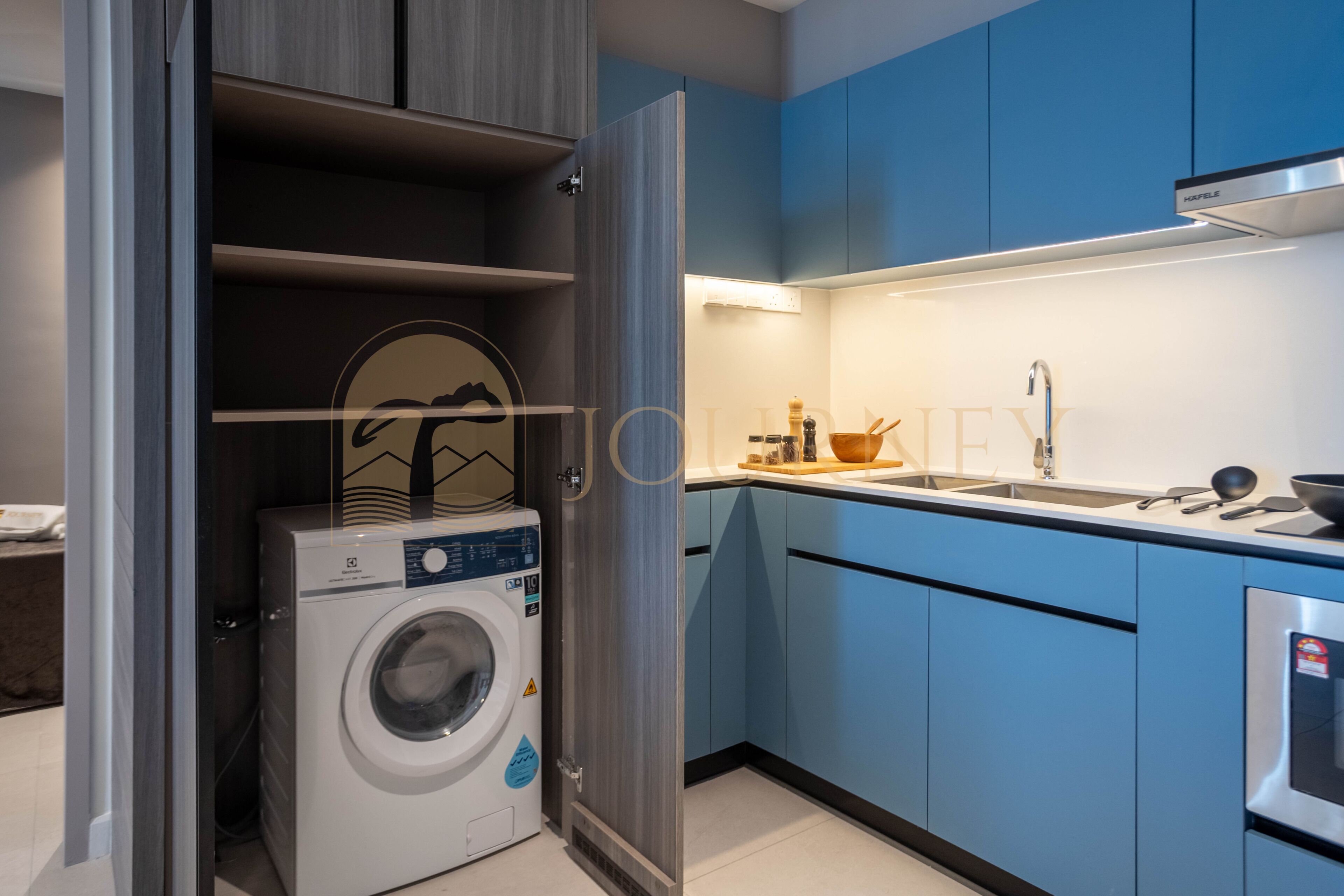 A compact kitchen with a built-in washing machine, a sink, and a stove.
