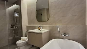 A modern bathroom with a toilet, sink, and bathtub.