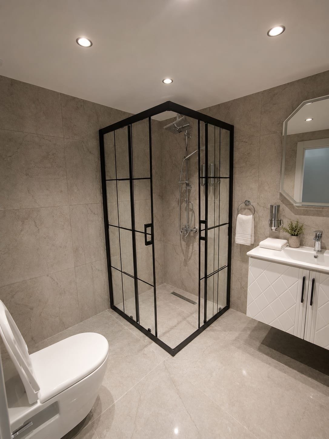 Een moderne badkamer met een douchecabine van glas, een toilet en een wastafel met spiegel.