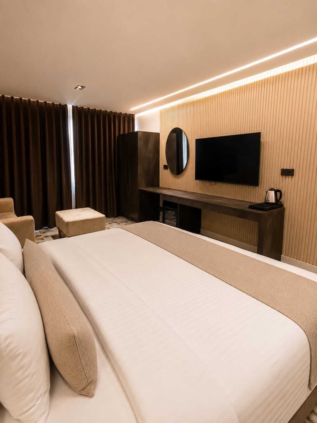 Une chambre d’hôtel équipée d’un lit, d’une télévision, d’un bureau et d’une machine à café.