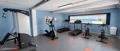 A gym with treadmills, an elliptical, and a bench.