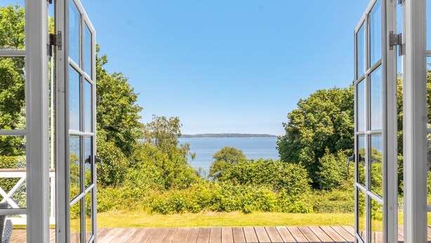 An open deck with a view of a body of water and surrounding greenery. - "Leea" - 100m from the sea by Interhome (Børkop)