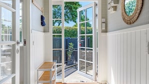 A room with a sliding glass door leading to a balcony, a wooden bench, and a wall-mounted mirror. - "Leea" - 100m from the sea by Interhome (Børkop)