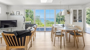 A modern living room with a TV, comfortable seating, a dining area, and a large window with a view. - "Leea" - 100m from the sea by Interhome (Børkop)