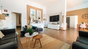Ein modernes Wohnzimmer mit Sofa, Couchtisch und Essbereich mit Tisch und Stühlen.