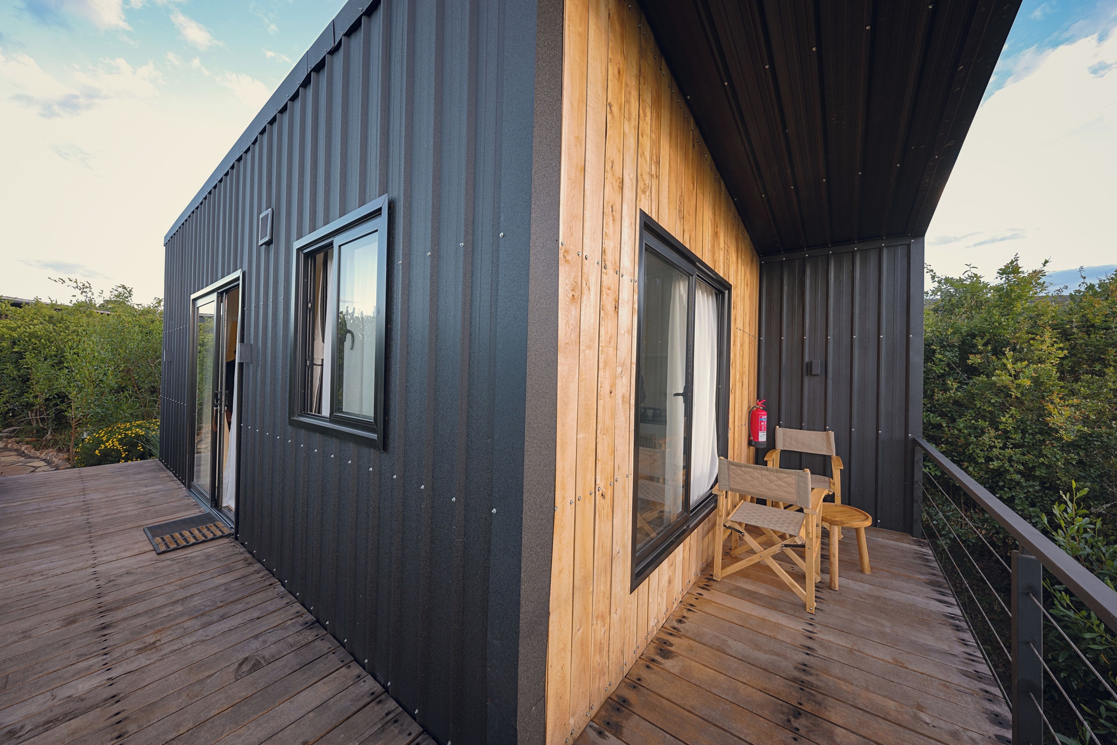 A modern building with a wooden deck and a fire extinguisher.