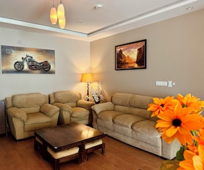 A living room with two sofas, a coffee table, a lamp, and two wall-mounted paintings. - Luxe 2BHK Private Garden Flat by ORR Tech Parks (Bengaluru)