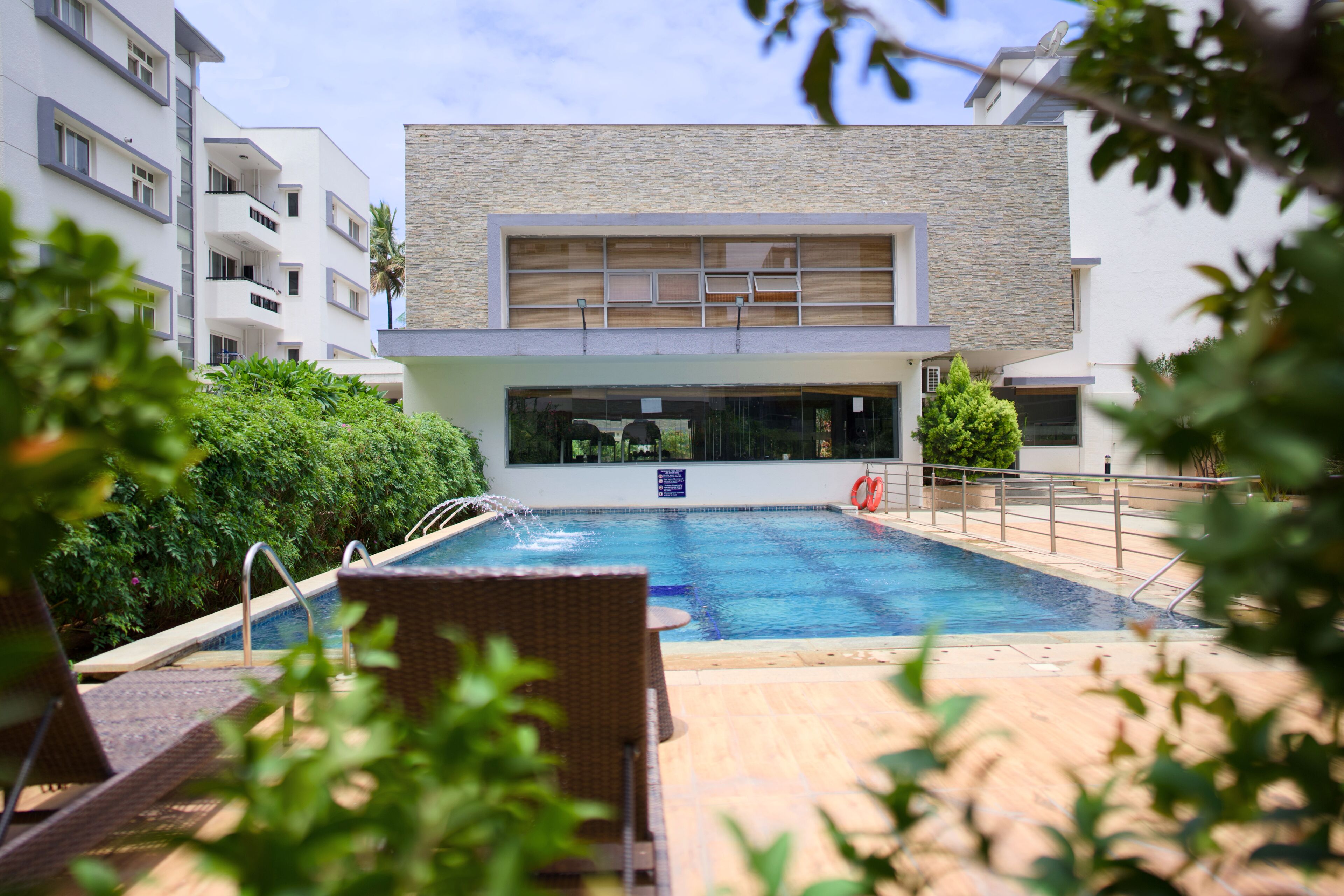 Un edificio moderno con piscina, lettini e vista sulla piscina.