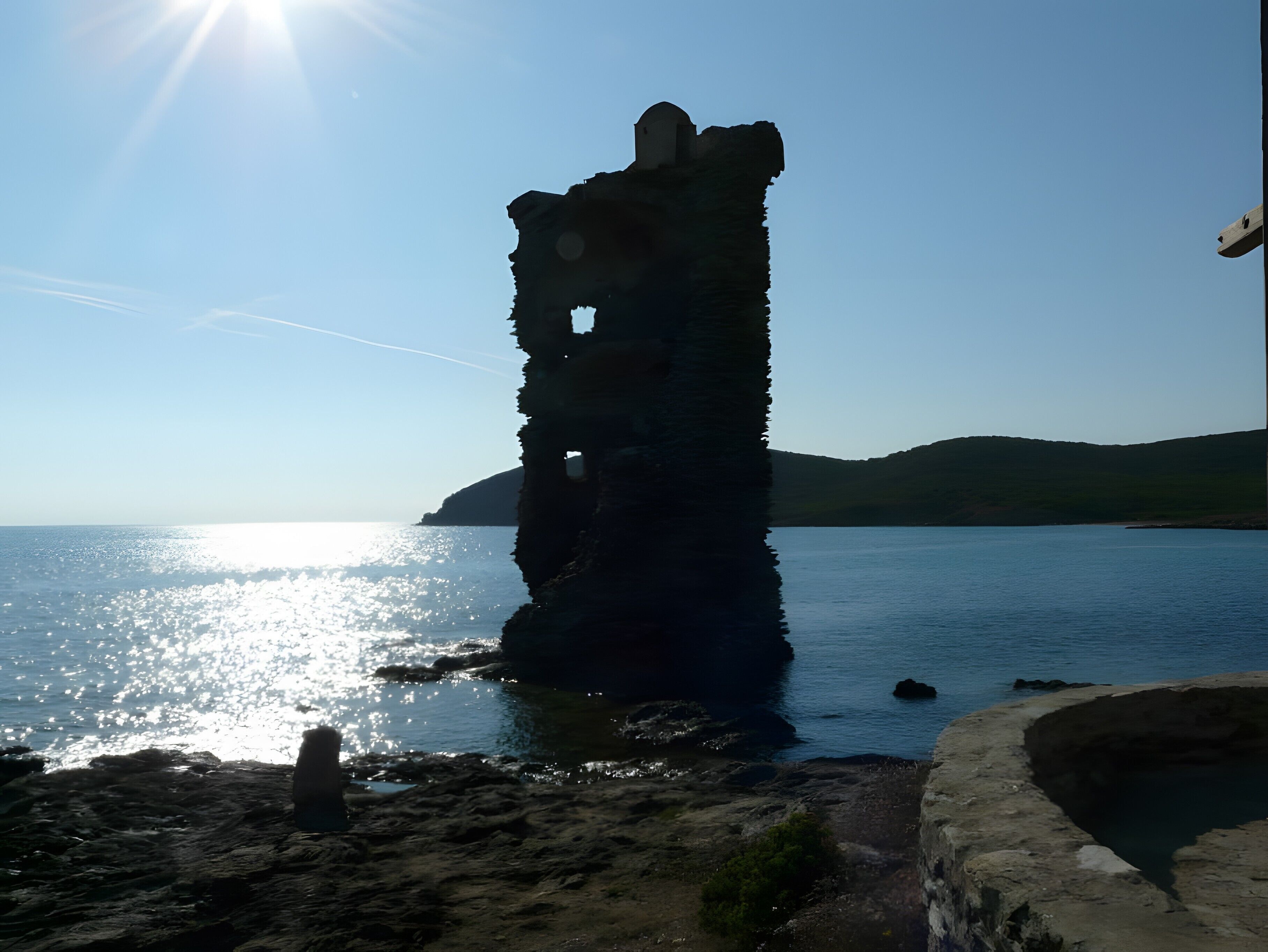 A coastal ruin with a clear sky and calm sea.