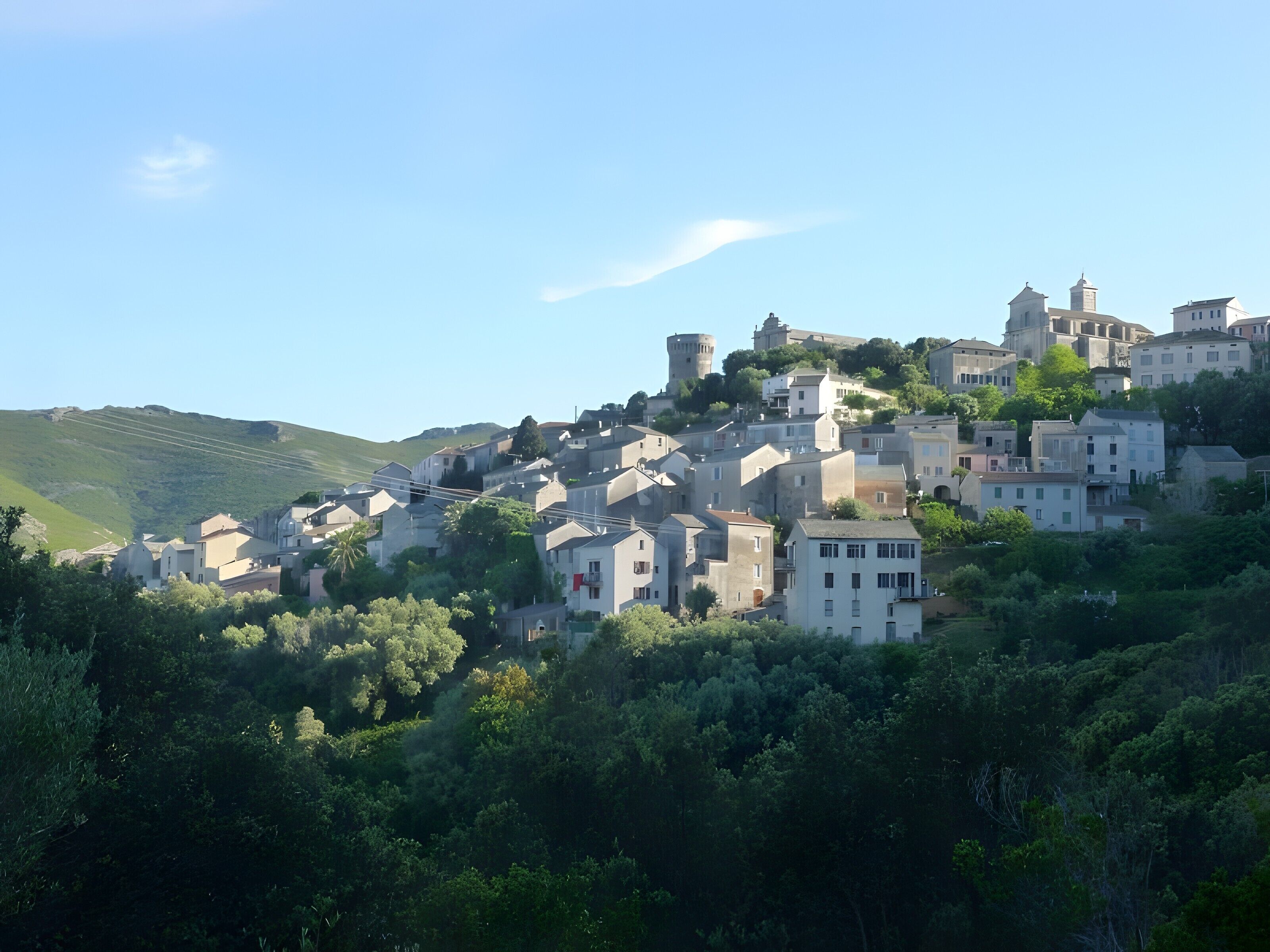Un village perché sur une colline, doté d’une architecture traditionnelle, avec notamment une tour et des bâtiments pourvus de balcons.
