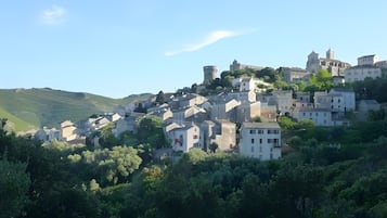 Un village perché sur une colline, doté d’une architecture traditionnelle, avec notamment une tour et des bâtiments pourvus de balcons.