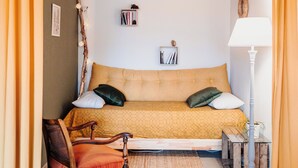 A cozy bedroom with a bed, a chair, a lamp, and a small table. - NEW ACCOMMODATIONS IN A VILLAGE HOUSE (Orschwiller)