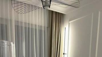 Una sala de estar con un sofá marrón, una mesa blanca con una vela y fotografías, y un perro.
