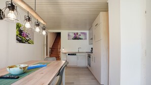 Une cuisine moderne avec des meubles blancs, un plan de travail en bois et un lave-vaisselle encastré.