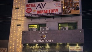 A hotel with a sign indicating it is a dormitory, featuring a contact number and a price tag.