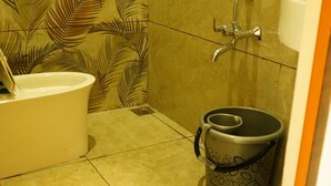 Un baño con bañera, inodoro y un cubo de basura.