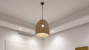 Un dormitori modern amb un llit, una tauleta de nit amb una làmpada, un armari i un quadre a la paret.
