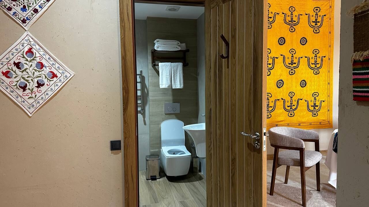 A bathroom with a toilet, sink, and towel rack.