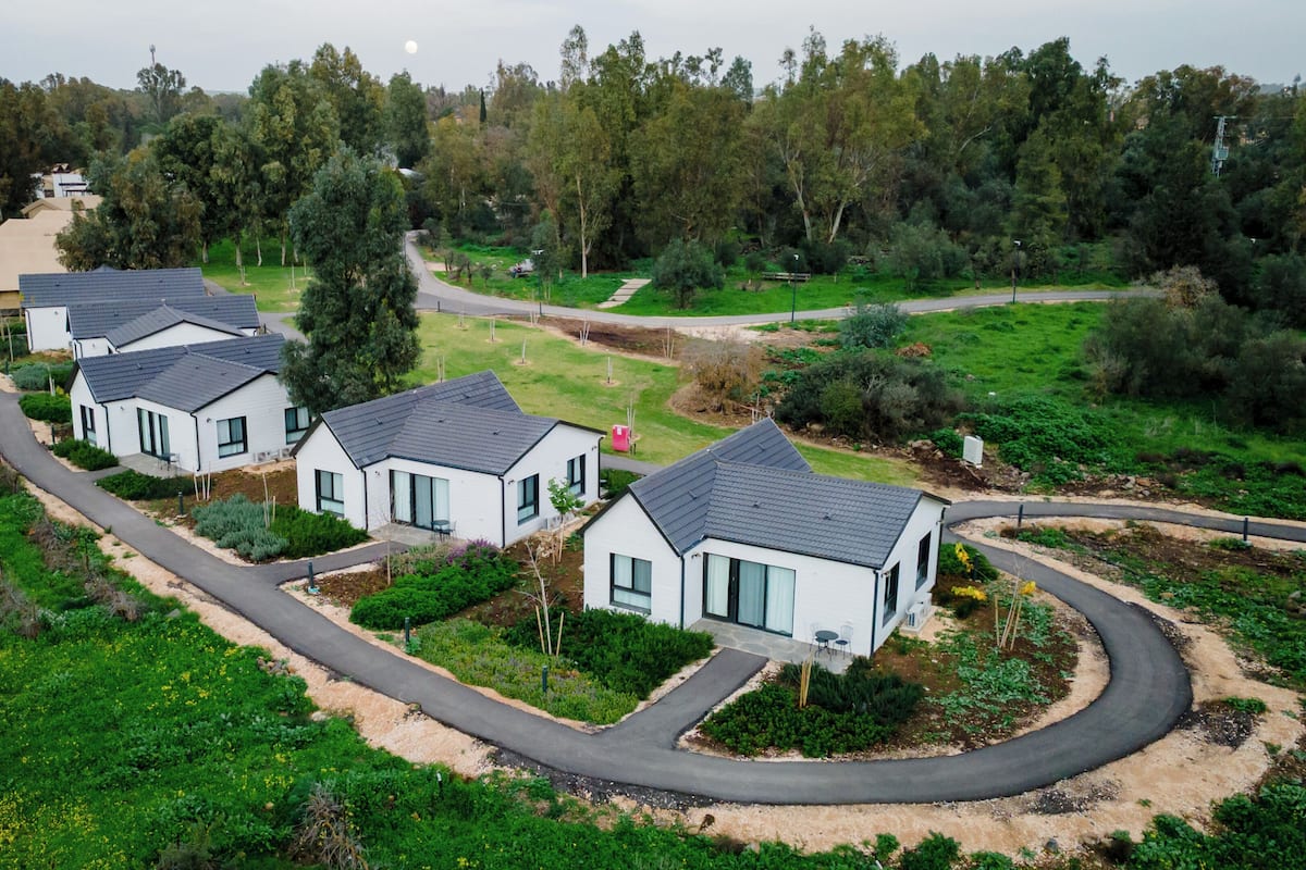 Ett bostadsområde med moderna hus, slingrande vägar och omgivande grönska.