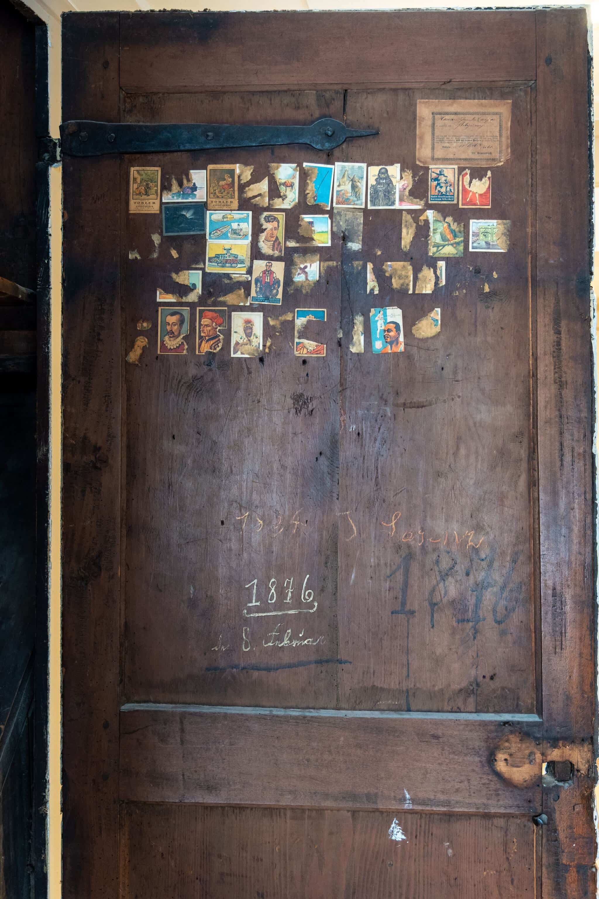 Eine Holztür mit verschiedenen Fotografien und handgeschriebenen Notizen.