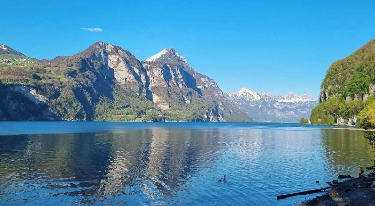 Un lac paisible, avec des montagnes en arrière-plan.