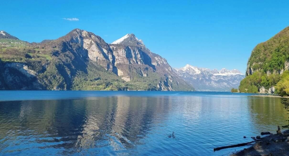 A calm lake with mountains in the background.